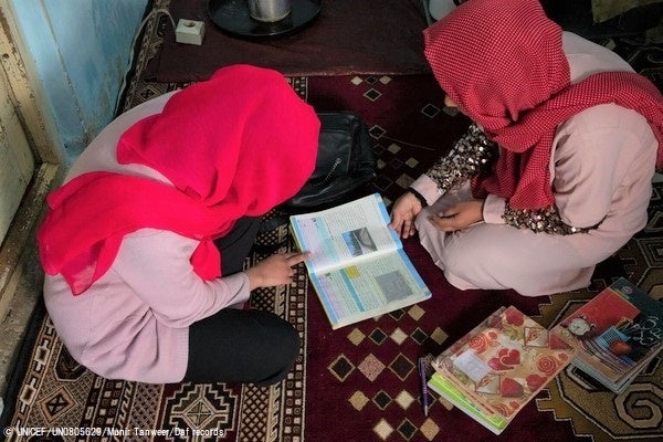 教員の父親から勉強を教わる高校2年生のアイシャさん。(アフガニスタン、2023年3月19日撮影) © UNICEF_UN0805629_Munir Tanweer_Daf records