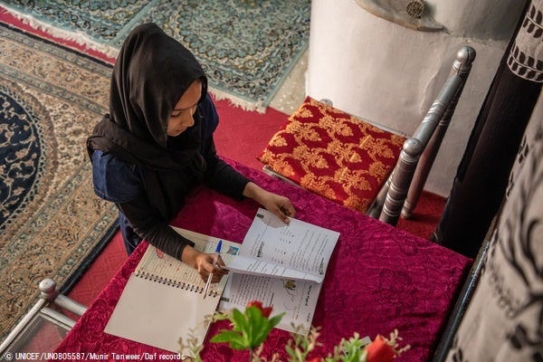 中等教育が禁止されたため、カブールの自宅で、前年度の教科書を使って勉強をする12歳のサマーさん。(アフガニスタン、2023年3月19日撮影) © UNICEF_UN0805587_Munir Tanweer_Daf records