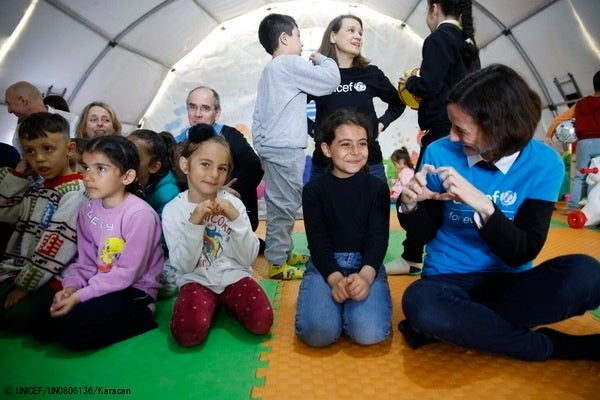 カフラマンマラシュの一時避難所にあるユニセフの子どもにやさしい空間で、ユニセフのスタッフと話す子どもたち。(トルコ、2023年3月16日撮影) © UNICEF_UN0806136_Karacan
