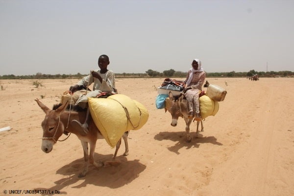 ロバに乗り、荷物を持って避難するスーダン難民。(チャド、2023年4月27日撮影) © UNICEF_UN0834337_Le Du