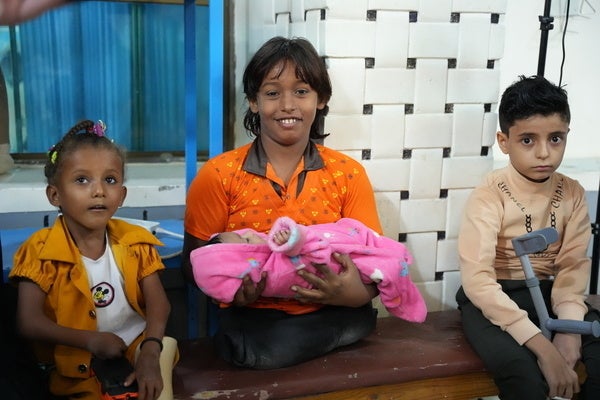 迫撃砲により負傷し、両足を切断したイマドさん(中央)。義肢・理学療法センターで、義足の使い方を学んだり理学療法を受けたりしている。(イエメン、2022年12月撮影) © UNICEF_UN0747990_Al-Azarqi