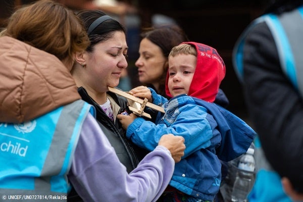 駅に設置されたユニセフの支援拠点「ブルードット」で、スタッフからおもちゃを受け取るウクライナ難民の子ども。(ポーランド、2022年10月撮影) © UNICEF_UN0727814_Reklajtis