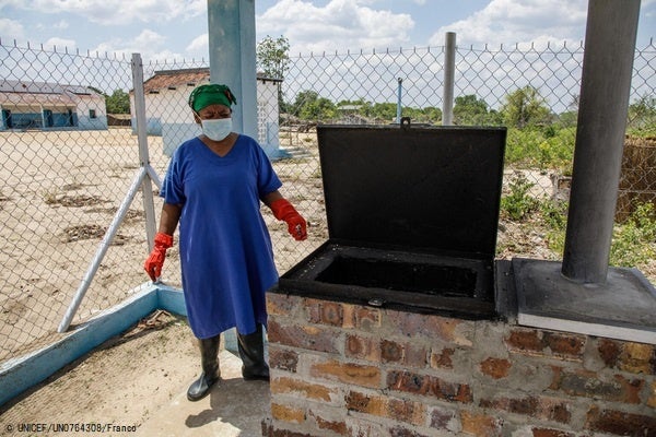 ナンプラ州のモナポにある保健センターの焼却炉のそばに立つ、病院の廃棄物責任者。新しくできた焼却炉はフェンスで囲まれ、安全な場所に設置されていて、他の人は出入りできないようになっている。(モザンビーク、2022年11月撮影) © UNICEF_UN07643