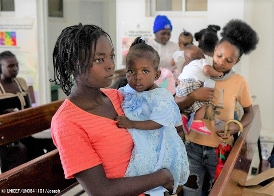 ユニセフの支援で、すぐに食べられる栄養治療食を受け取り、栄養不良から回復した子ども。しかし人々を取り巻く状況は悪く、この親子も経済的支援や栄養支援をまだ必要としている。(ハイチ、2023年5月10日撮影) © UNICEF_UN0841101_Joseph