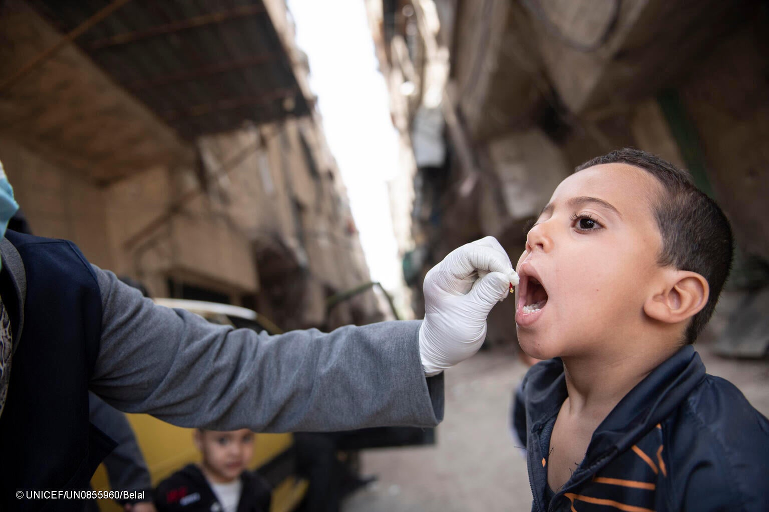 全国予防接種キャンペーンの一環で、ユニセフが支援する移動式保健チームのスタッフからポリオ予防接種の投与を受ける男の子。(シリア、2023年5月撮影) © UNICEF_UN0855960_Belal