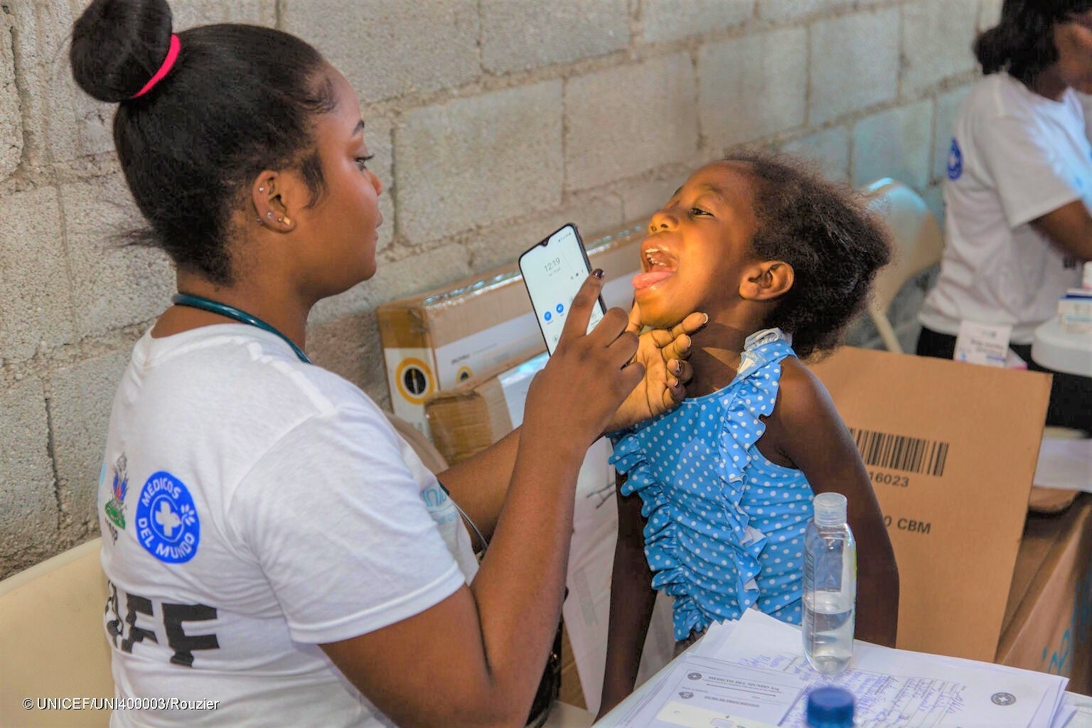 ポルトープランスの国内避難民キャンプで、健康状態のチェックを受ける女の子。武装勢力の暴力により、このキャンプには500人以上の人が避難しており、その半数近くが子どもたちである。(ハイチ、2023年6月撮影) © UNICEF_UNI400003_Rouzi