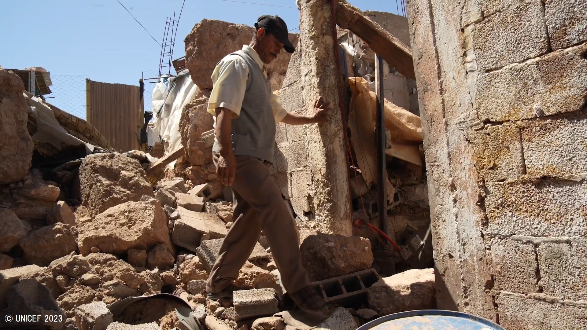マラケシュのアルホウズ州にある村で、地震により倒壊した自宅を確認する男性。(モロッコ、2023年9月10日撮影※映像より切り取り) © UNICEF 2023