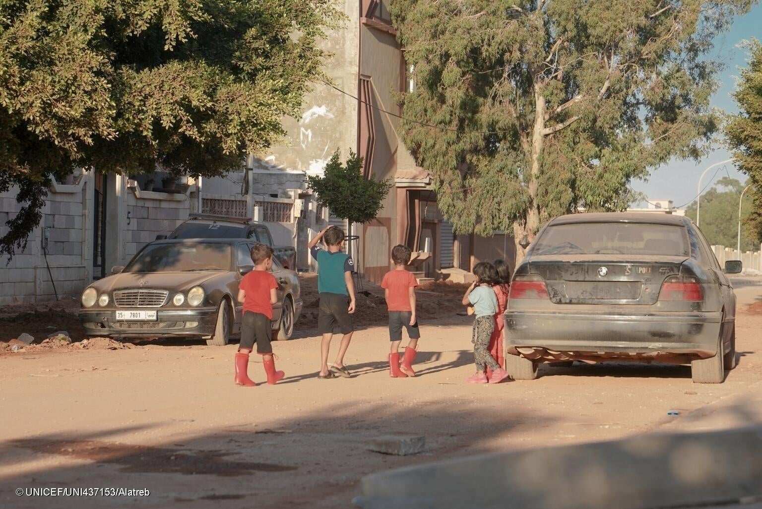 洪水で被災し新しい町に避難してきた子どもたち。天気が晴れの日も、再び洪水が発生することを警戒して長靴を履いている。(リビア、2023年9月14日撮影) © UNICEF_UNI437153_Alatreb