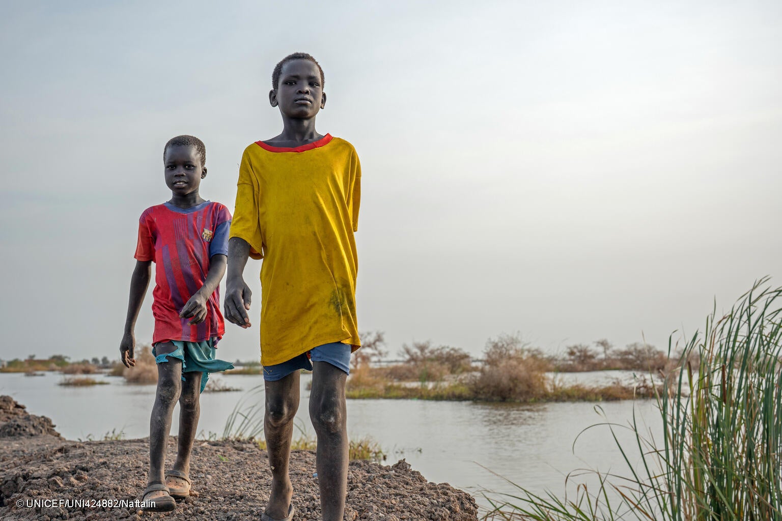 ユニティ州のベンティウで、洪水により浸水した道を歩く男の子たち。(南スーダン、2023年2月撮影) © UNICEF_UNI424882_Naftalin