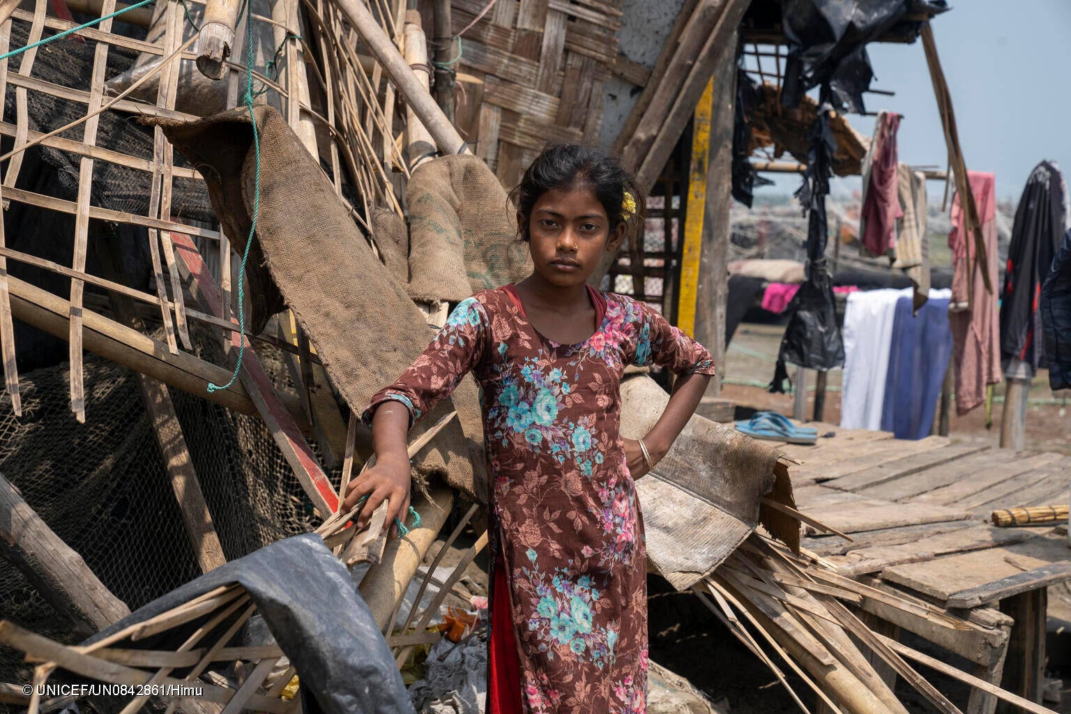 テクナフ郡で、サイクロン「モカ」により破壊された自宅前に立つ女の子。(バングラデシュ、2023年5月撮影) © UNICEF_UN0842861_Himu