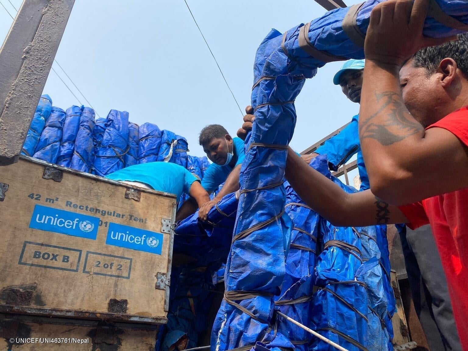 ジャジャルコット郡に向かうトラックに、防水シートや毛布などを含むユニセフの緊急支援物資を積み込むユニセフのスタッフ。(ネパール、2023年11月4日撮影) © UNICEF_UNI463761_Nepal