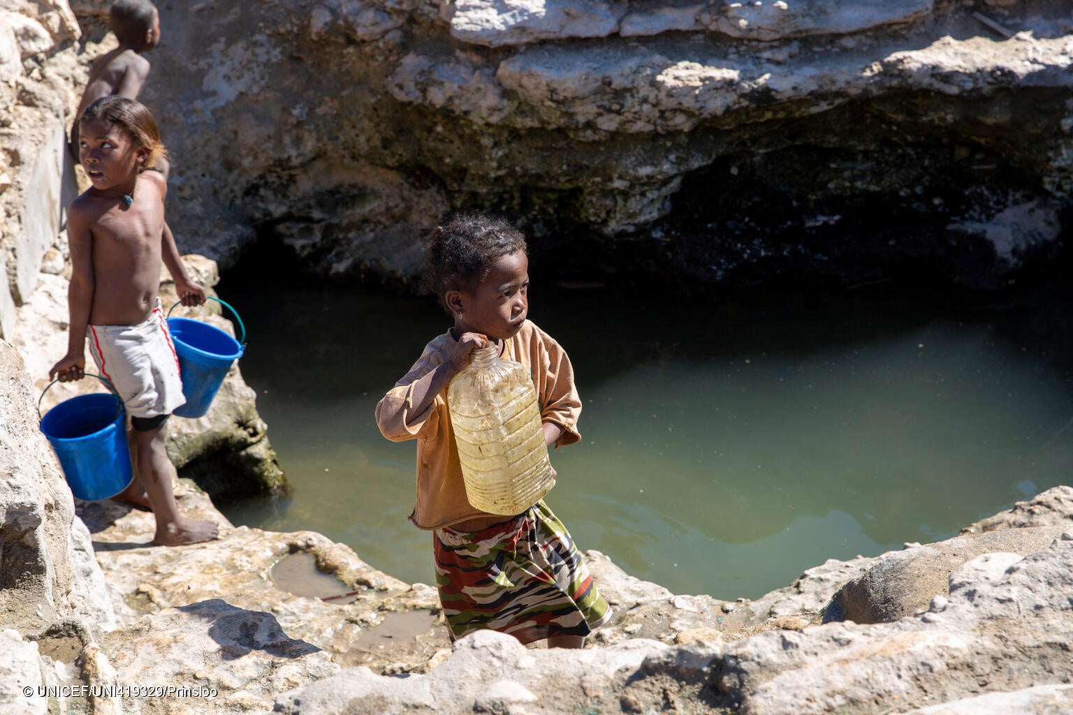 南西部の村で、海水が混じり濁った水を汲む子ども。何年も続く干ばつにより農作物は枯れ、深刻な食料不足に直面している。(マダガスカル、2023年7月撮影) © UNICEF_UNI419329_Prinsloo