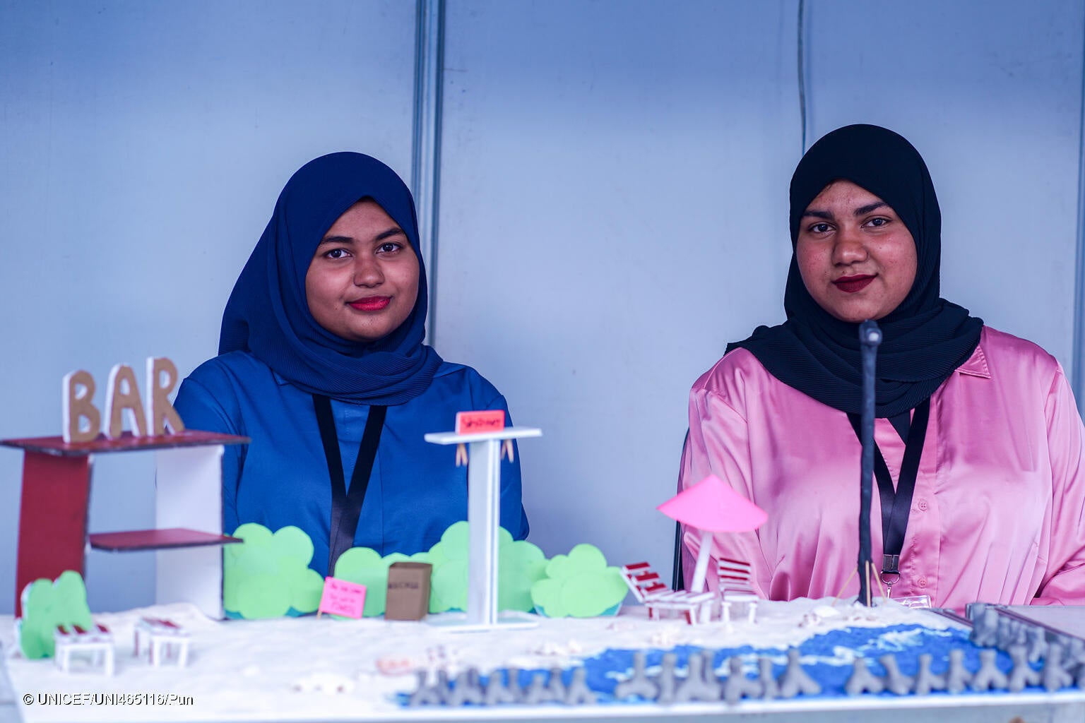 気候変動の若者全国会議で、地球温暖化により海面上昇で浸食される海岸を守るための対策案を発表するシャファフさん(17、左)とシャファーさん(16、右)。2人の自宅は海岸の近くにあり、日常生活に影響することを心配している。(モルディブ、2023年10月撮影)