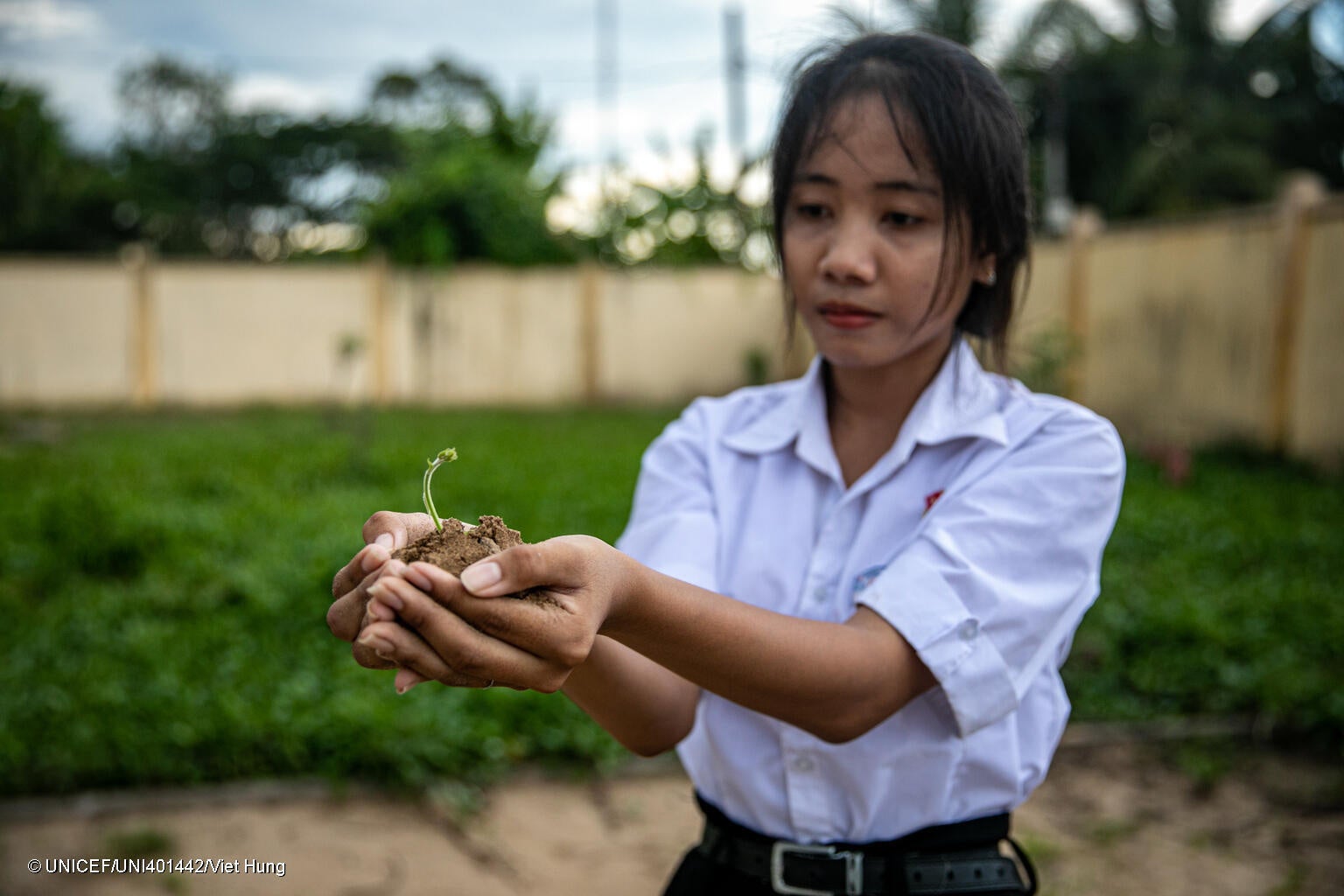 ソクチャン省の中学校で、植物の苗を手に持つ15歳のラムさん。授業で、気候変動は家族や友人にどのような影響を与えるかを学んだ。(ベトナム、2023年5月撮影) © UNICEF_UNI401442_Viet Hung