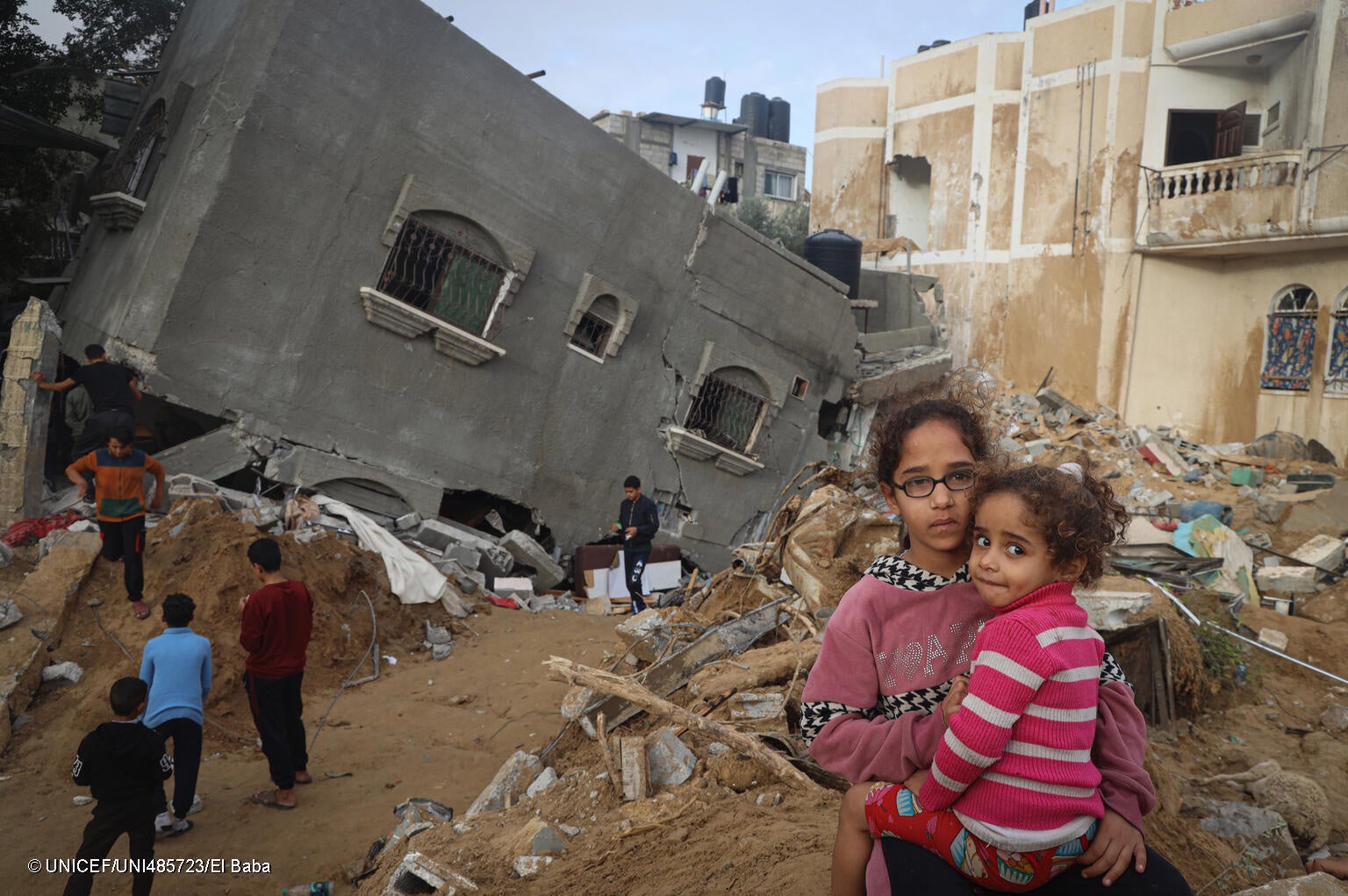 南部ラファの自宅が破壊された4歳のザラちゃんと12歳のアビアさん姉妹。「おもちゃも服も勉強道具も全部なくなった。教科書もないし学校はどうしたらいいの…」と、アビアさんは話す。(ガザ地区、2023年11月26日撮影) © UNICEF_UNI485723_E