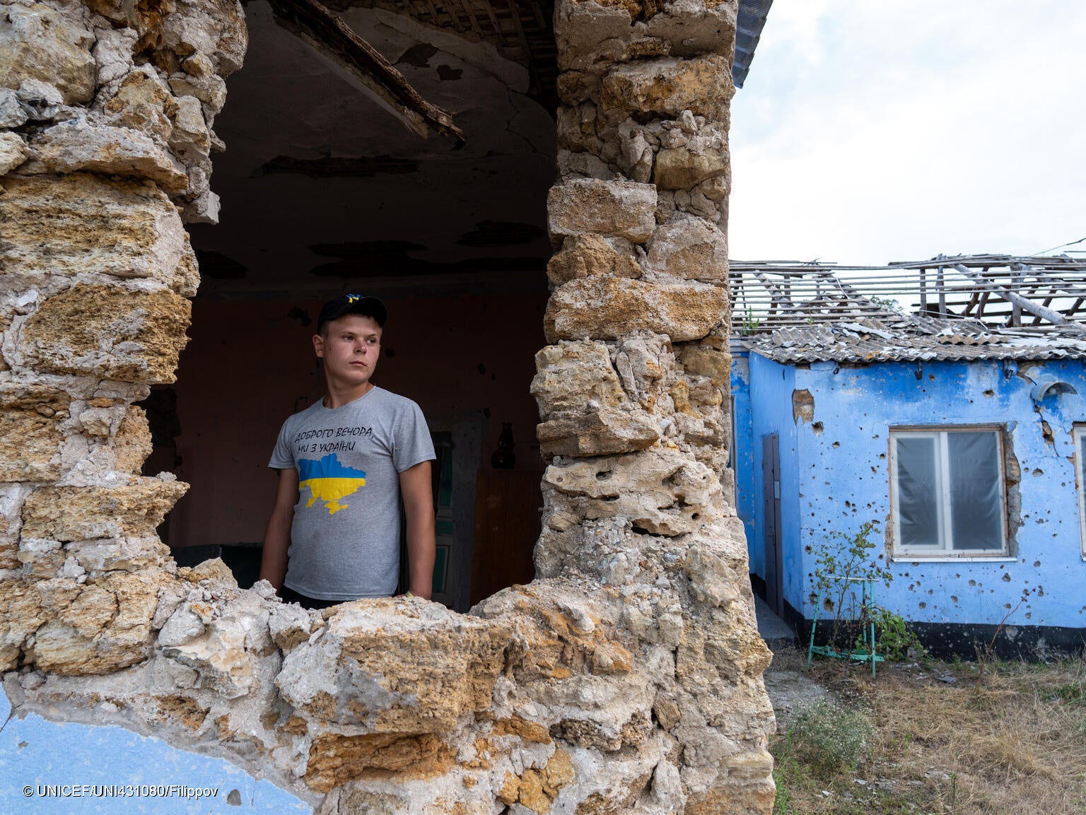 ドネツク州にある通っていた学校が破壊され、大きな穴の開いた校舎の中に立つ15歳のサシュコさん。(ウクライナ、2023年7月撮影) © UNICEF_UNI431080_Filippov