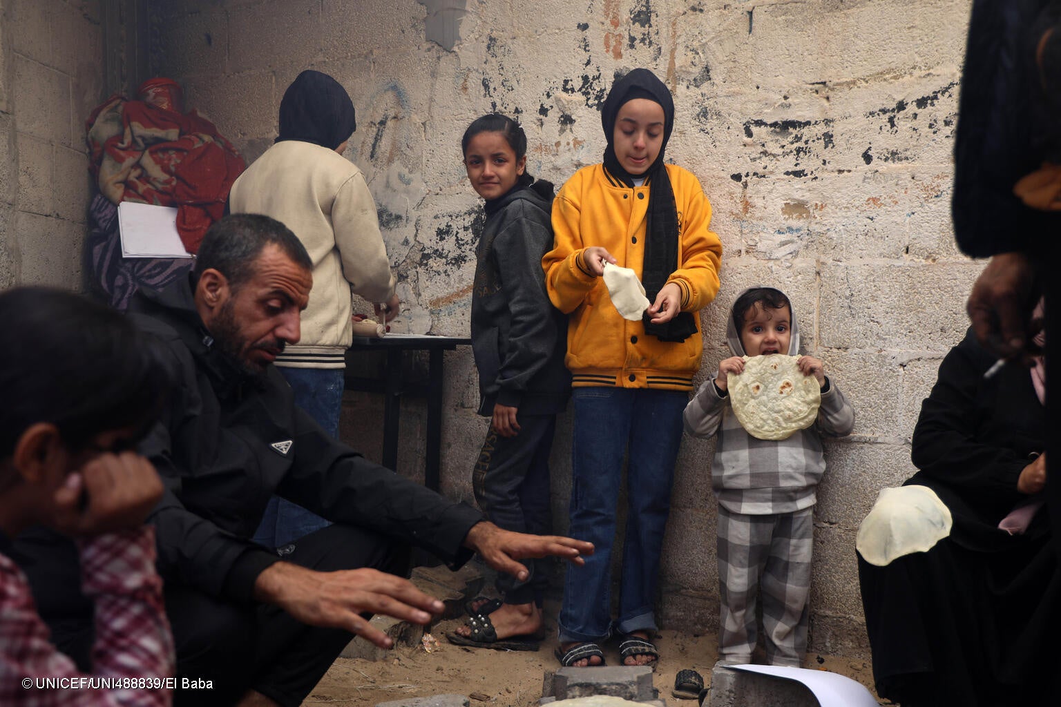 ハンユニスの避難所で、小麦粉からパンを作る家族。(ガザ地区、2023年12月6日撮影) © UNICEF_UNI488839_El Baba