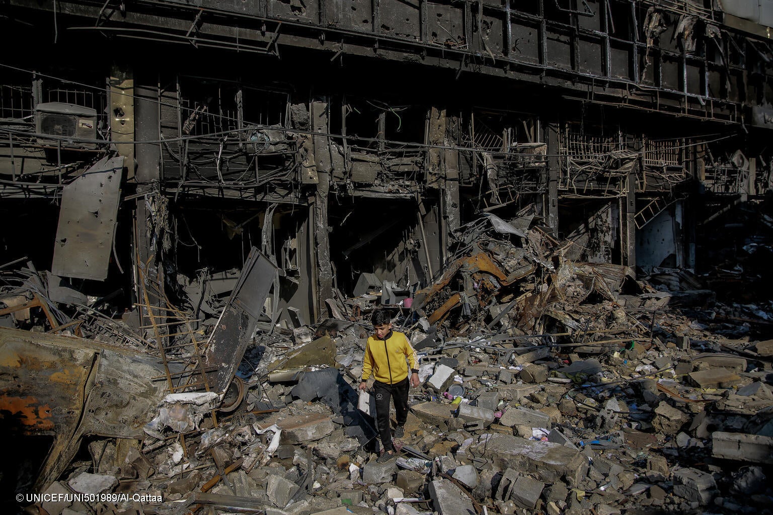 破壊された自宅のがれきの上を歩く11歳のアリさん。(ガザ地区、2024年1月11日撮影) © UNICEF_UNI501989_Al-Qattaa