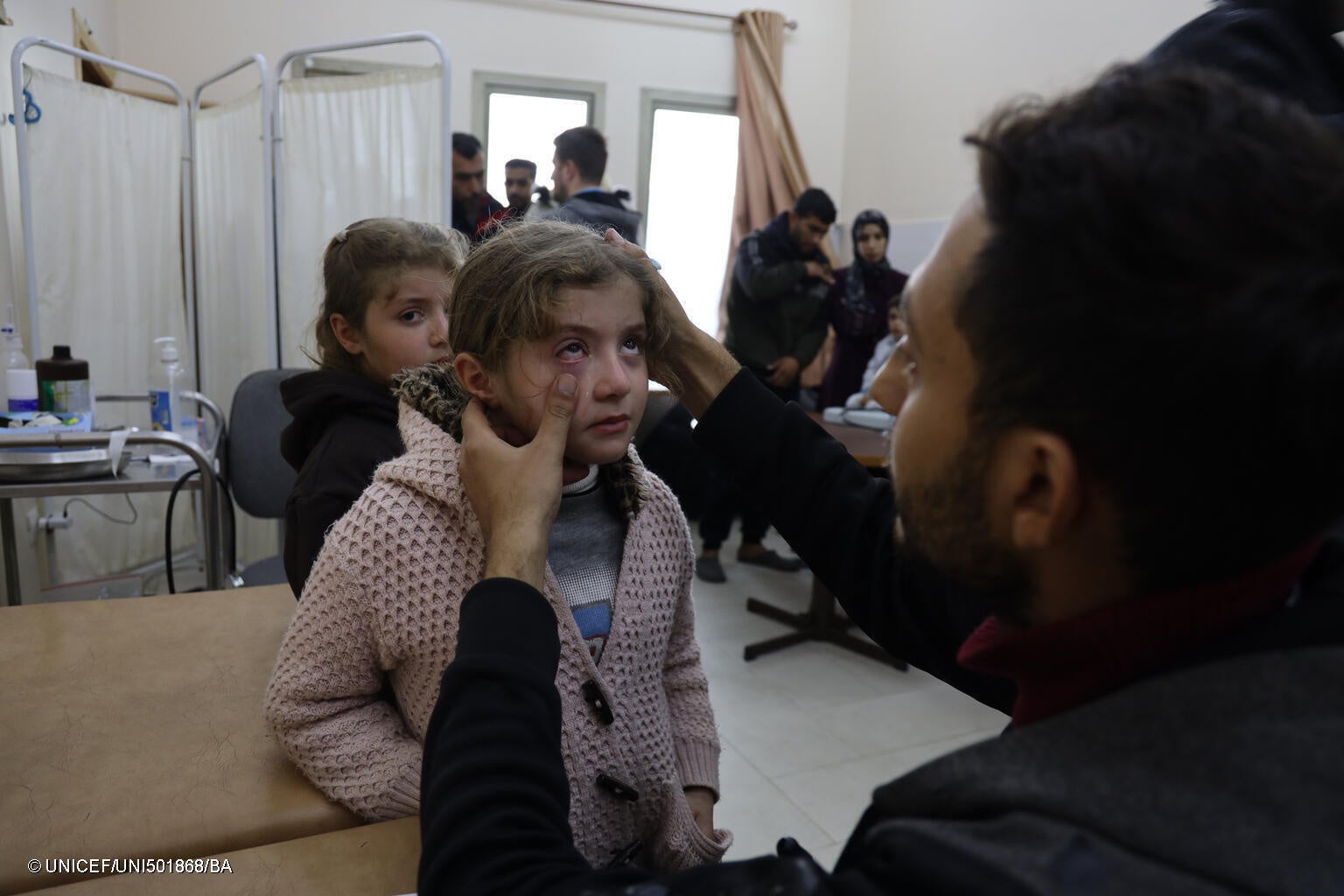 アル・アクサ大学内の避難所で診察を受ける女の子。「1日に約200人の子どもを診察していますが、ほとんどの子どもに下痢や皮膚炎の症状があります」と、医師は話す。(ガザ地区、2024年1月11日撮影) © UNICEF_UNI501868_BA