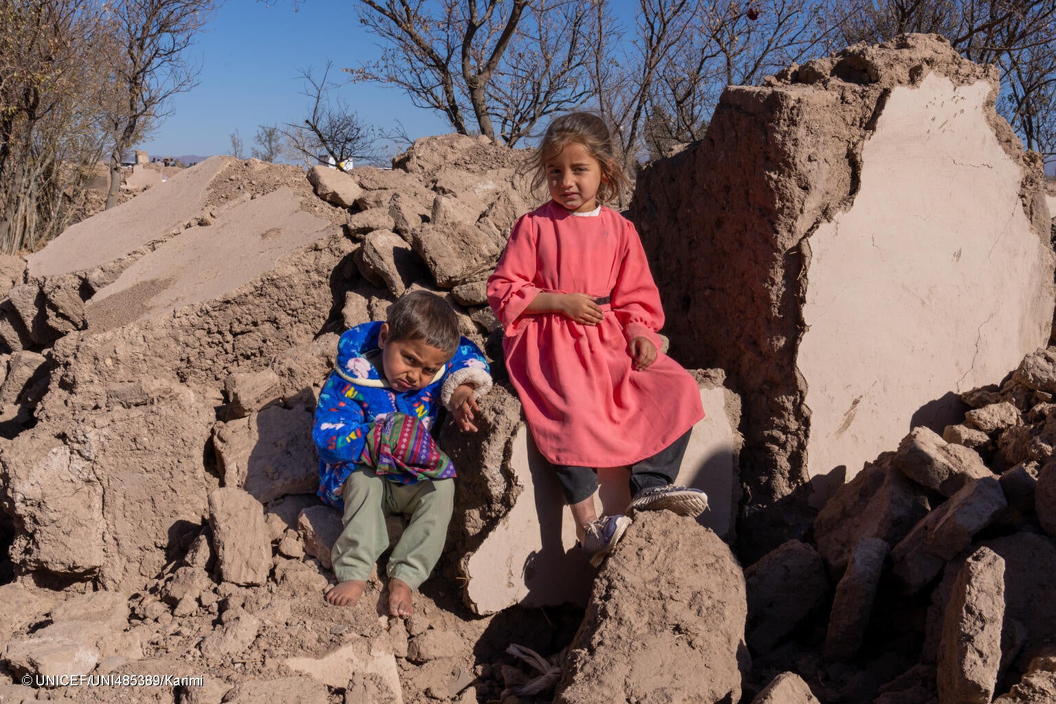 ヘラートで、地震により倒壊した自宅のがれきの上に座る子どもたち。(アフガニスタン、2023年12月3日撮影) © UNICEF_UNI485389_Karimi
