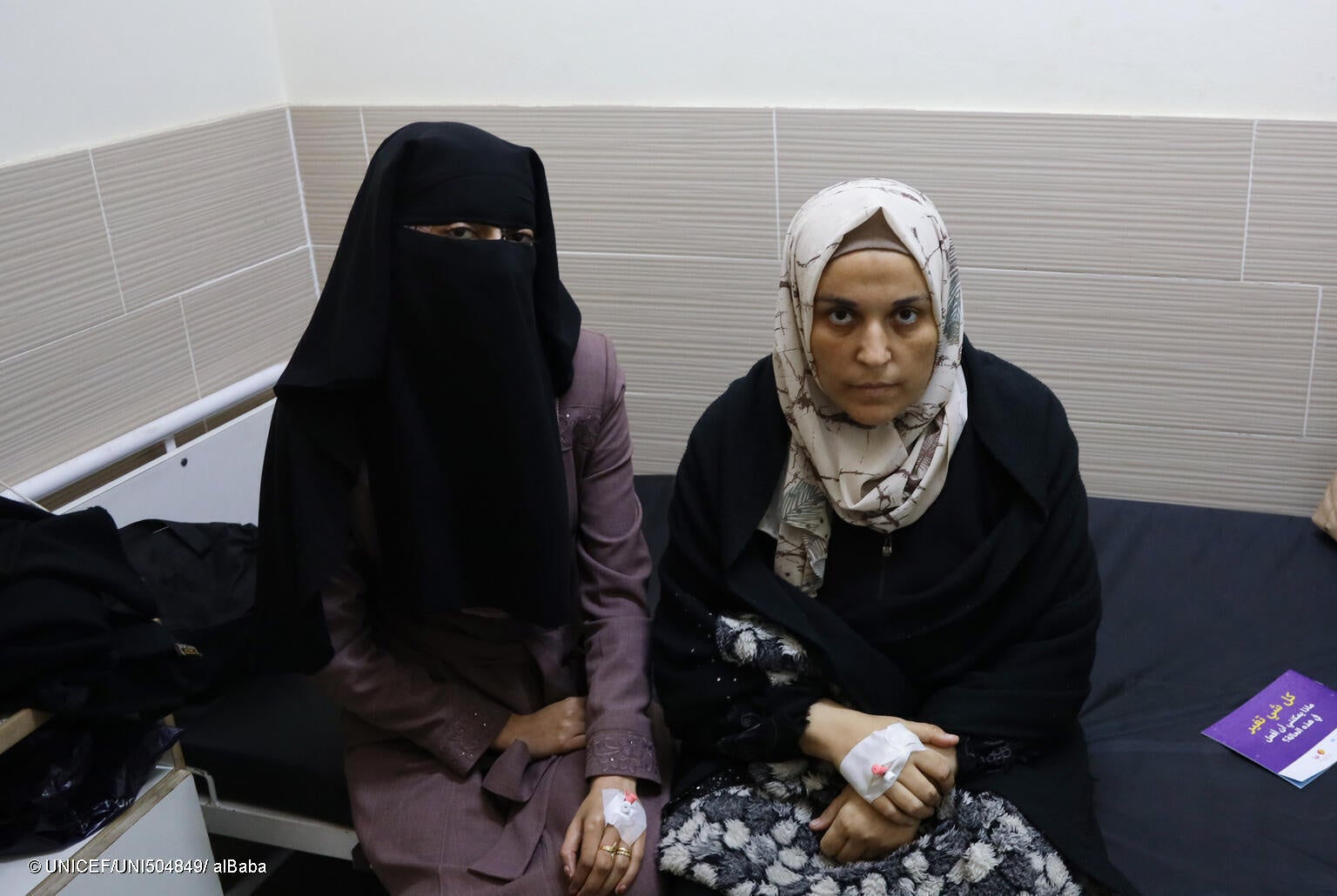 ベッドの上に座るイマンさん(右)とマシェルさん(左)。エミラティ産科病院は満床状態で、医療従事者も不足し、合併症の患者が増加している。(ガザ地区、2024年1月12日撮影) © UNICEF_UNI504849_ alBaba