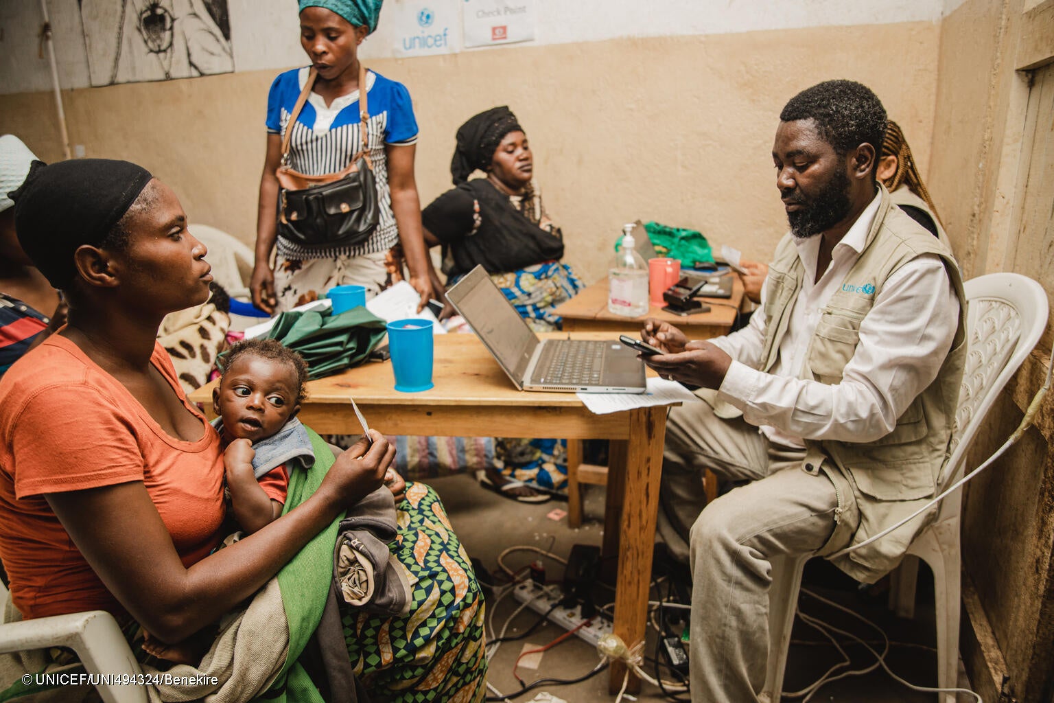 南キブ州で、ユニセフの支援物資を受け取る母親と子ども。今後3カ月間、生活に必要な食料等を買うための現金給付を受け取ることができる。(コンゴ民主共和国、2023年12月撮影) © UNICEF_UNI494324_Benekire