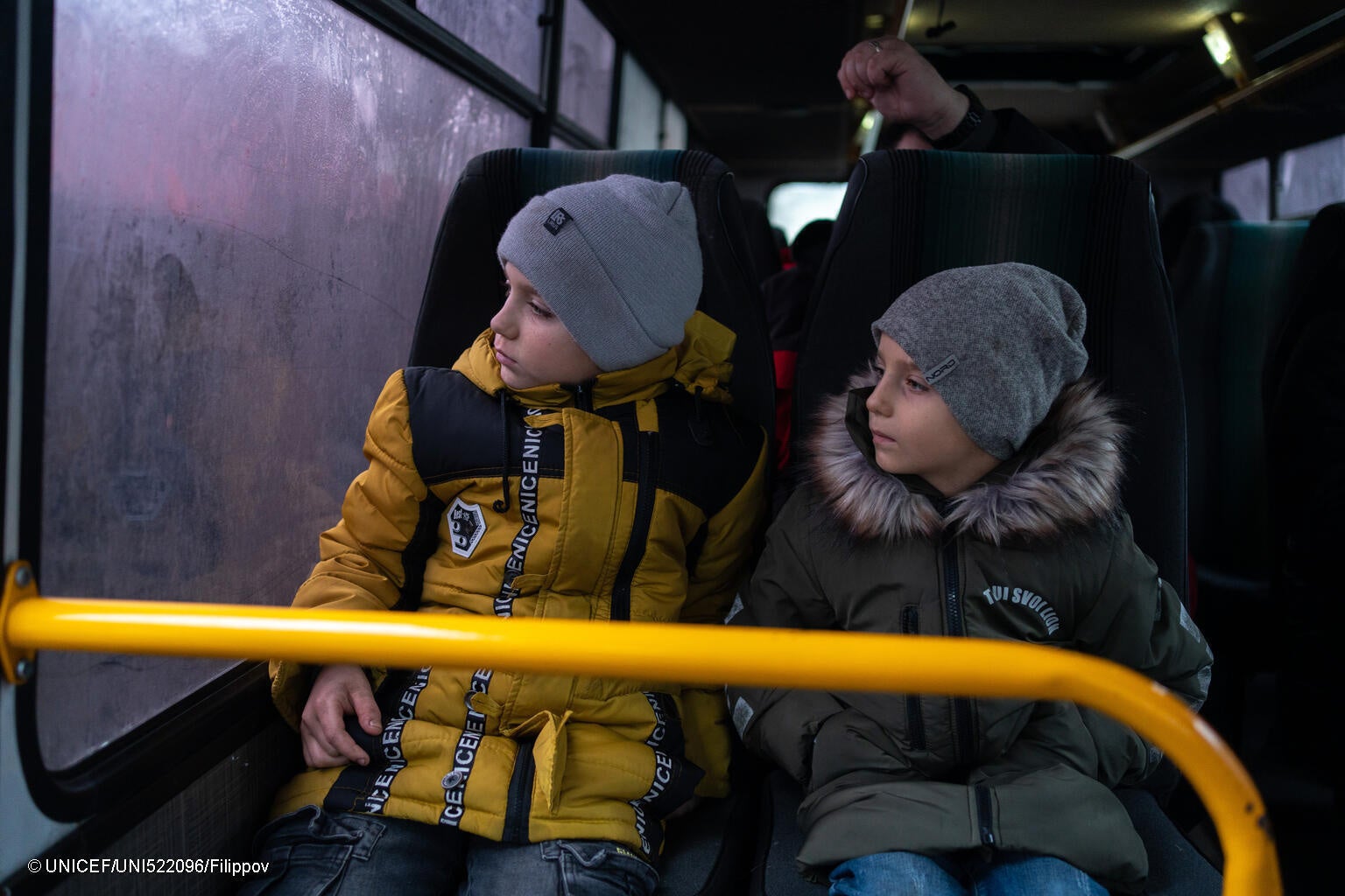 ドネツクから親戚のいるドニプロへ向かうバスに乗る10歳のミキータさんと6歳のセルヒーさん兄弟。避難する前日にユニセフから受け取った冬服を着用している。(ウクライナ、2024年1月撮影) © UNICEF_UNI522096_Filippov
