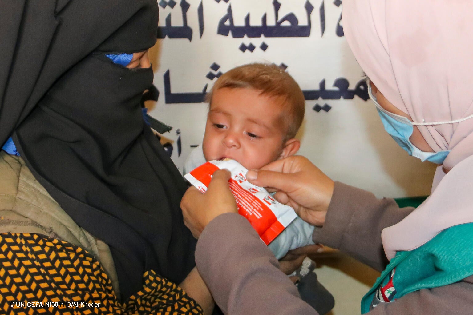 デリゾールの村に設置されたユニセフ支援の移動式クリニックで、すぐに食べられる栄養治療食(RUTF)を口にする生後8カ月のヨセフちゃん。 (シリア、2023年11月撮影) © UNICEF_UNI501110_Al-Kheder