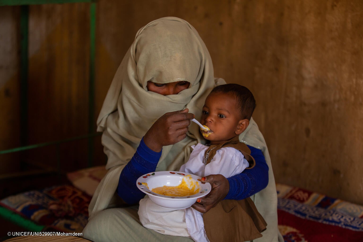 生後9カ月のムハメドちゃんに栄養価の高い食事を食べさせる母親。(スーダン、2024年2月撮影) © UNICEF_UNI529907_Mohamdeen