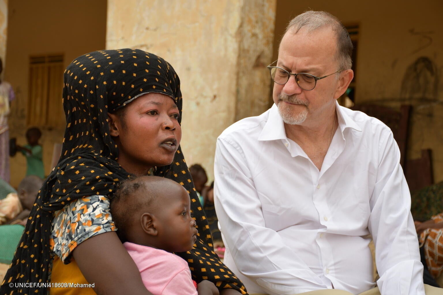 アトバラを訪れ、母親と話すユニセフ事務局次長のテッド・チャイバン。(スーダン、2023年7月撮影) © UNICEF_UNI418608_Mohamed