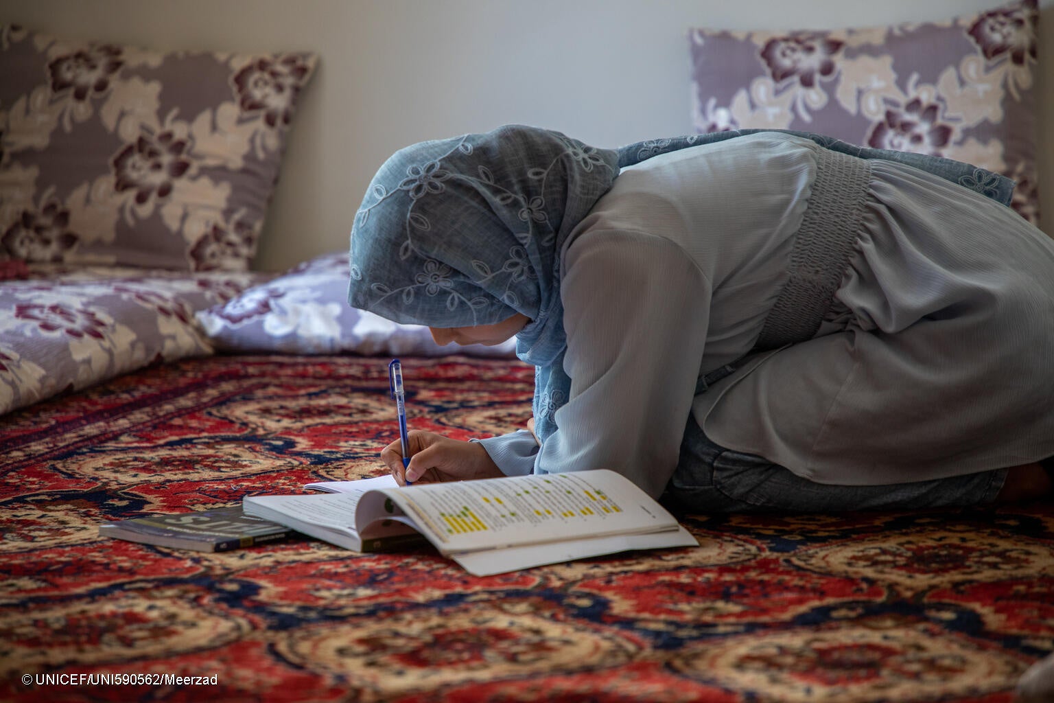 通学が禁止されてから3年が経つ中、自宅で家事をしながら英語の勉強を続ける16歳のザイナブさん(仮名)。「結婚した同級生の女の子もいます」と話す。(アフガニスタン、2024年6月8日撮影) © UNICEF_UNI590562_Meerzad