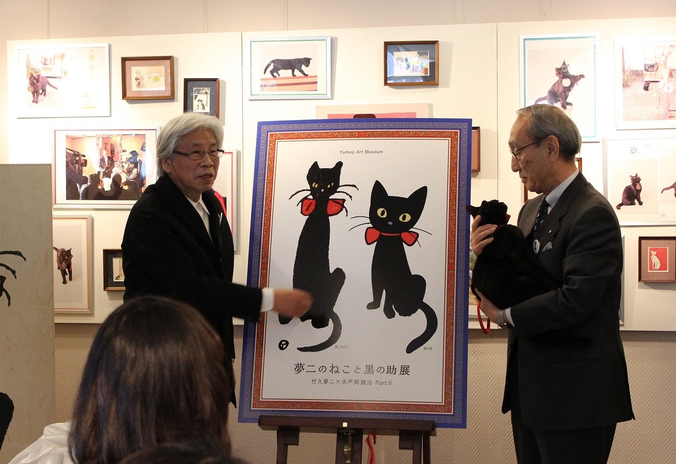 水戸岡鋭治と小嶋光信（「夢二のねこと黑の助展―  竹久夢二×水戸岡鋭治partⅡ」（2017年）のプレス発表時の写真）