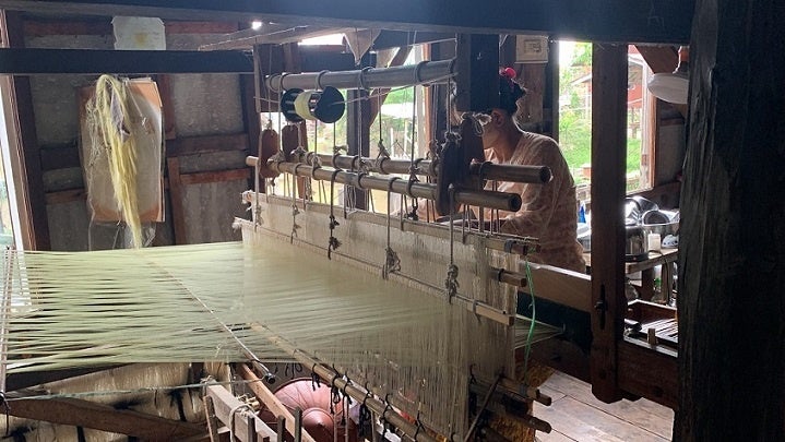 伝統的な織り機を使って蓮の布を作っていく