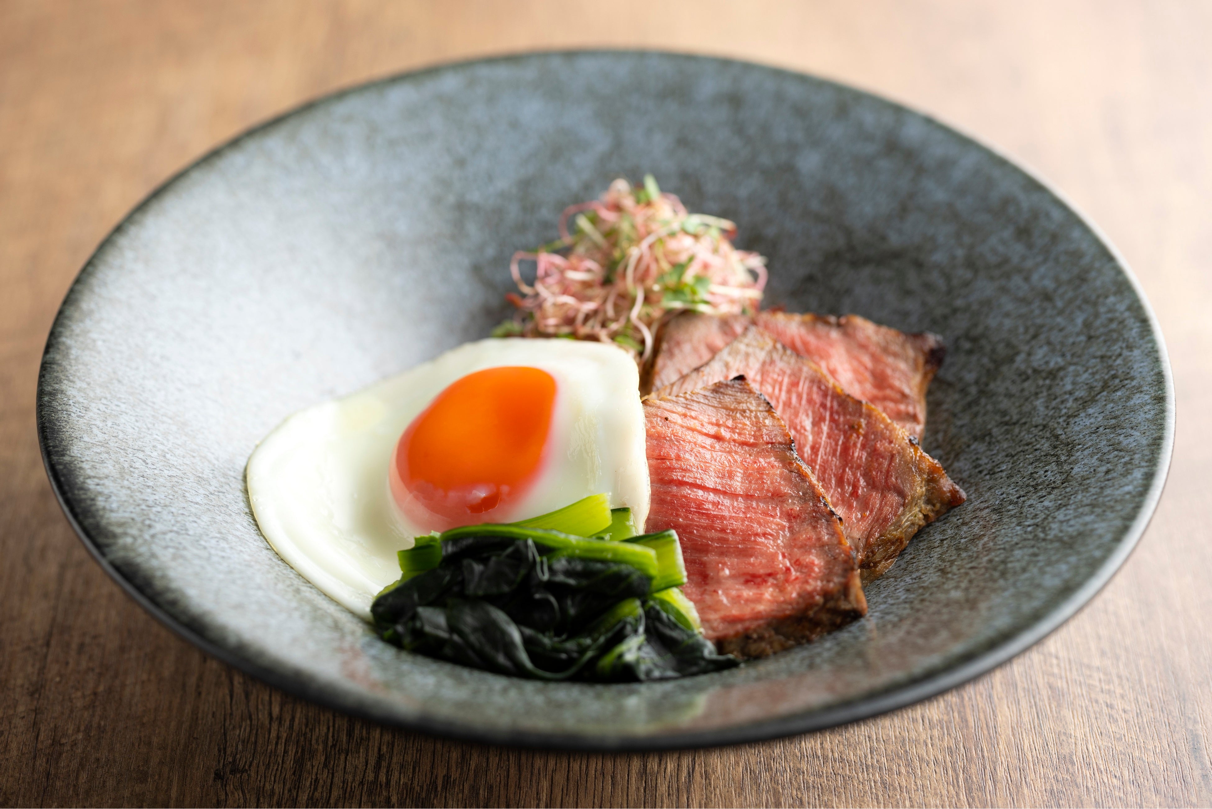 「プロテインボウル」 パエリアが起源とされるアメリカ南部の郷土料理「ジャンバラヤ」に、醤油麹でマリネしたサーロインステーキと目玉焼きを合わせた、高タンパクボウル。 ジムに通いや、ボディメイクをしている方に最適です。