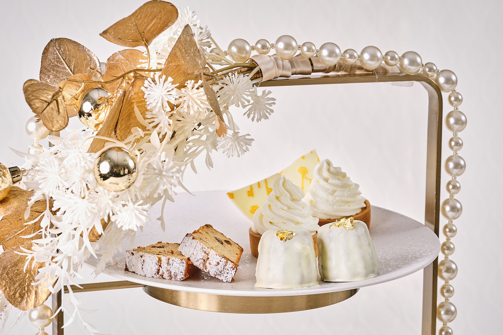 気品あふれるパールをまとったエレガントな装いのアフタヌーンティースタンドに並ぶ真っ白なスイーツの数々