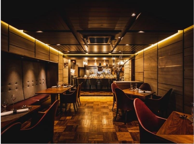 ⼤理⽯と⽊の素材を融合したメインダイニングとオープンキッチン