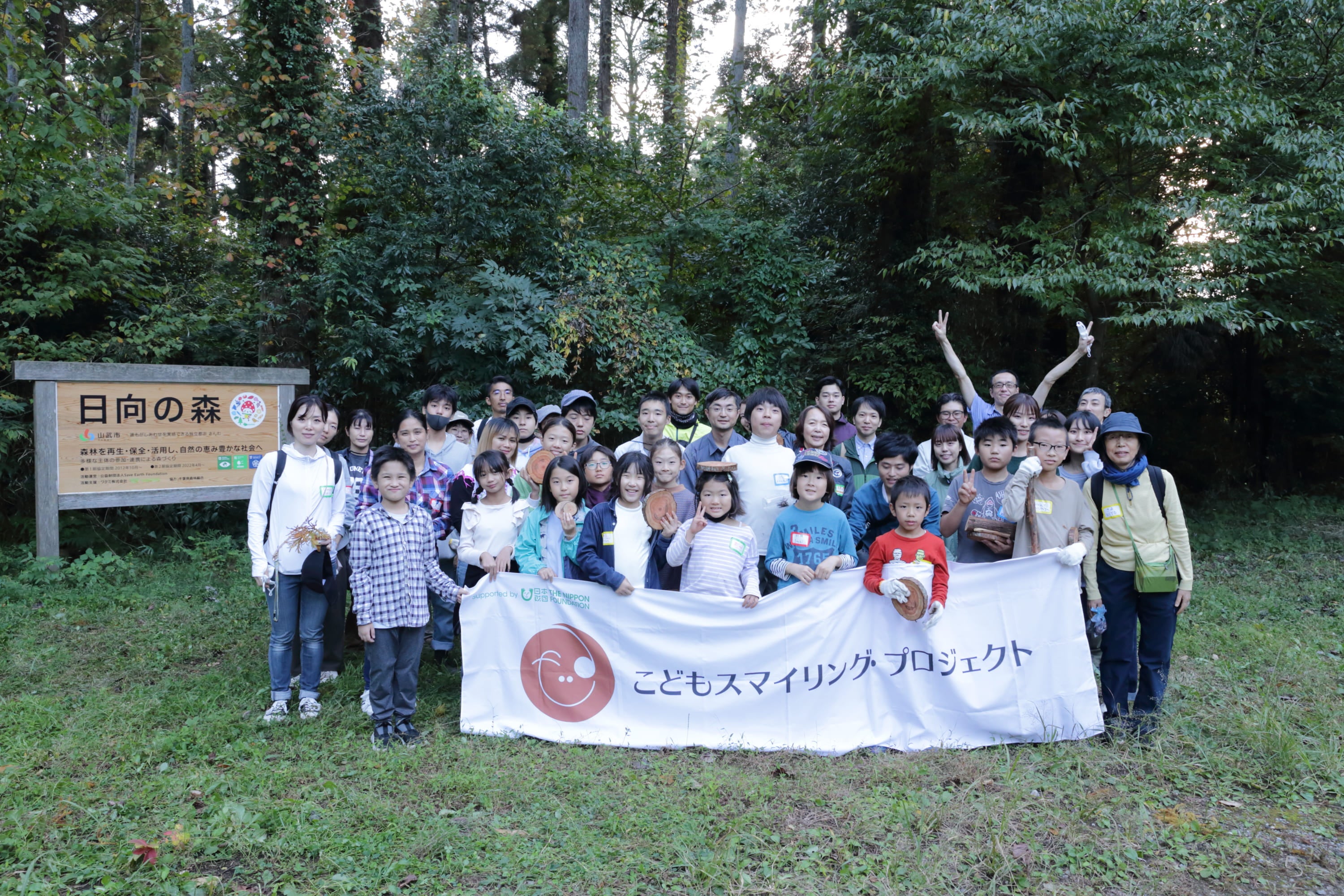 間伐材コースターをお土産にもらい集合写真