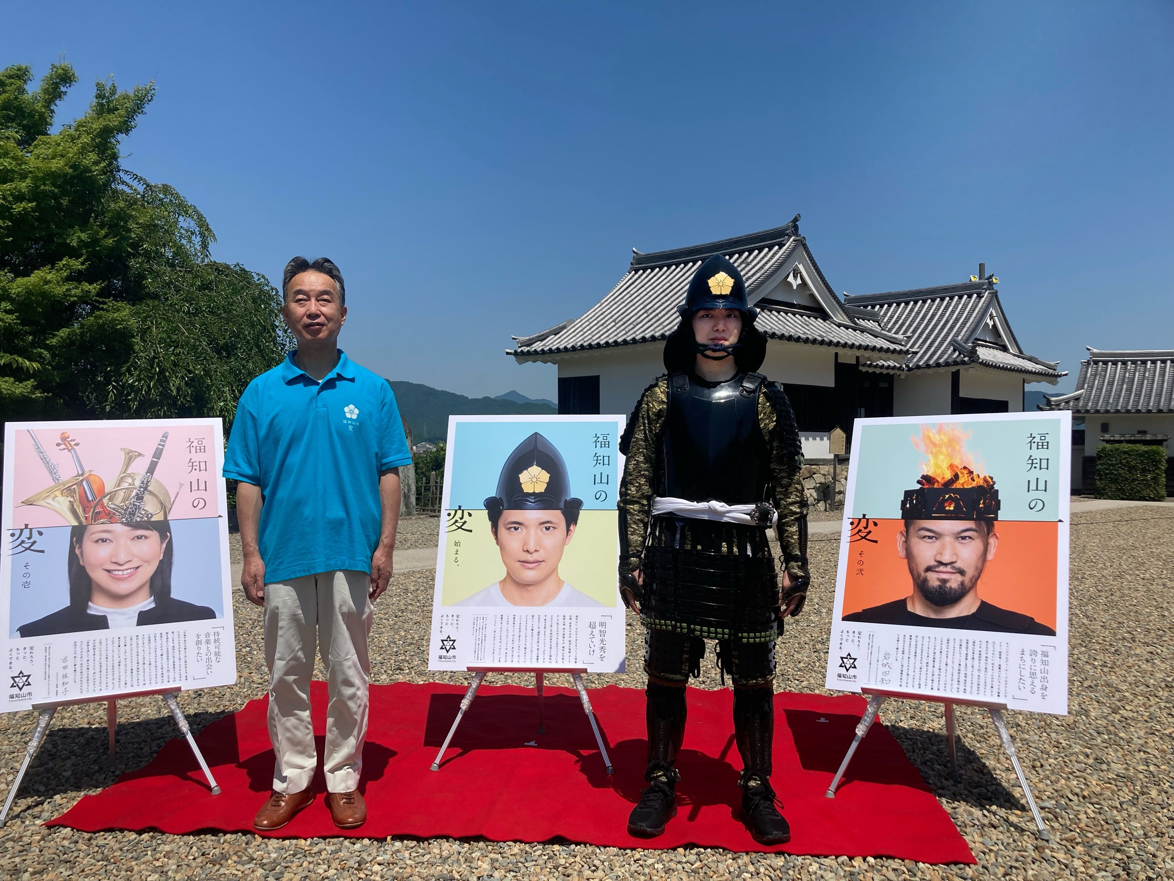 ポスターをお披露目する大橋一夫 福知山市長と甲冑姿の秋山蒼さん(写真右)