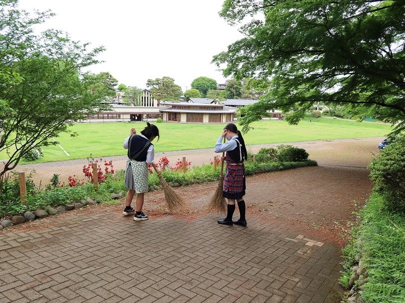 女子部遠景と坂道を掃除する生徒