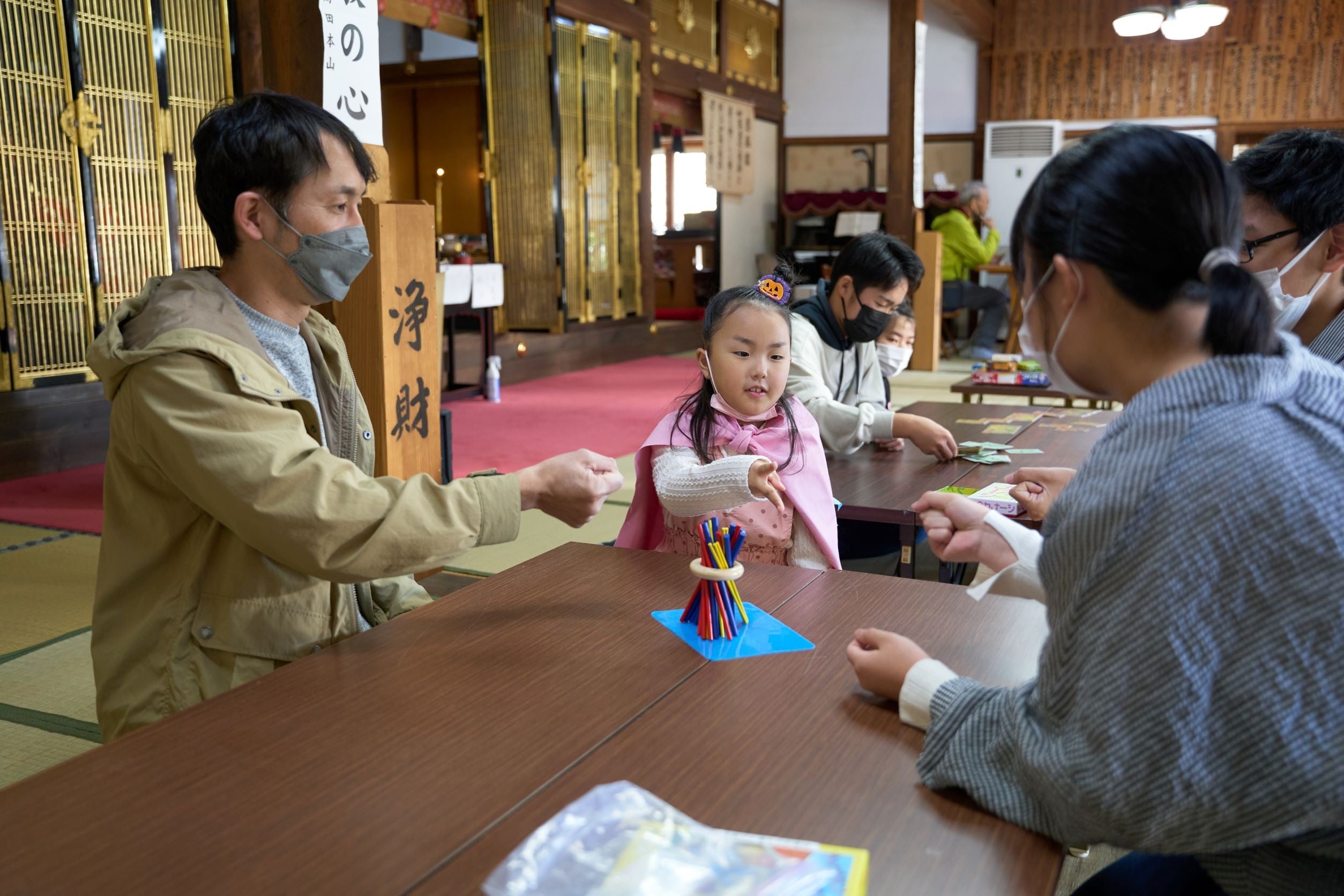 お寺の境内を開放！地域の中学生が運営ボランティアとして参加し、ボードゲームやバルーンアートを楽しむカフェに。