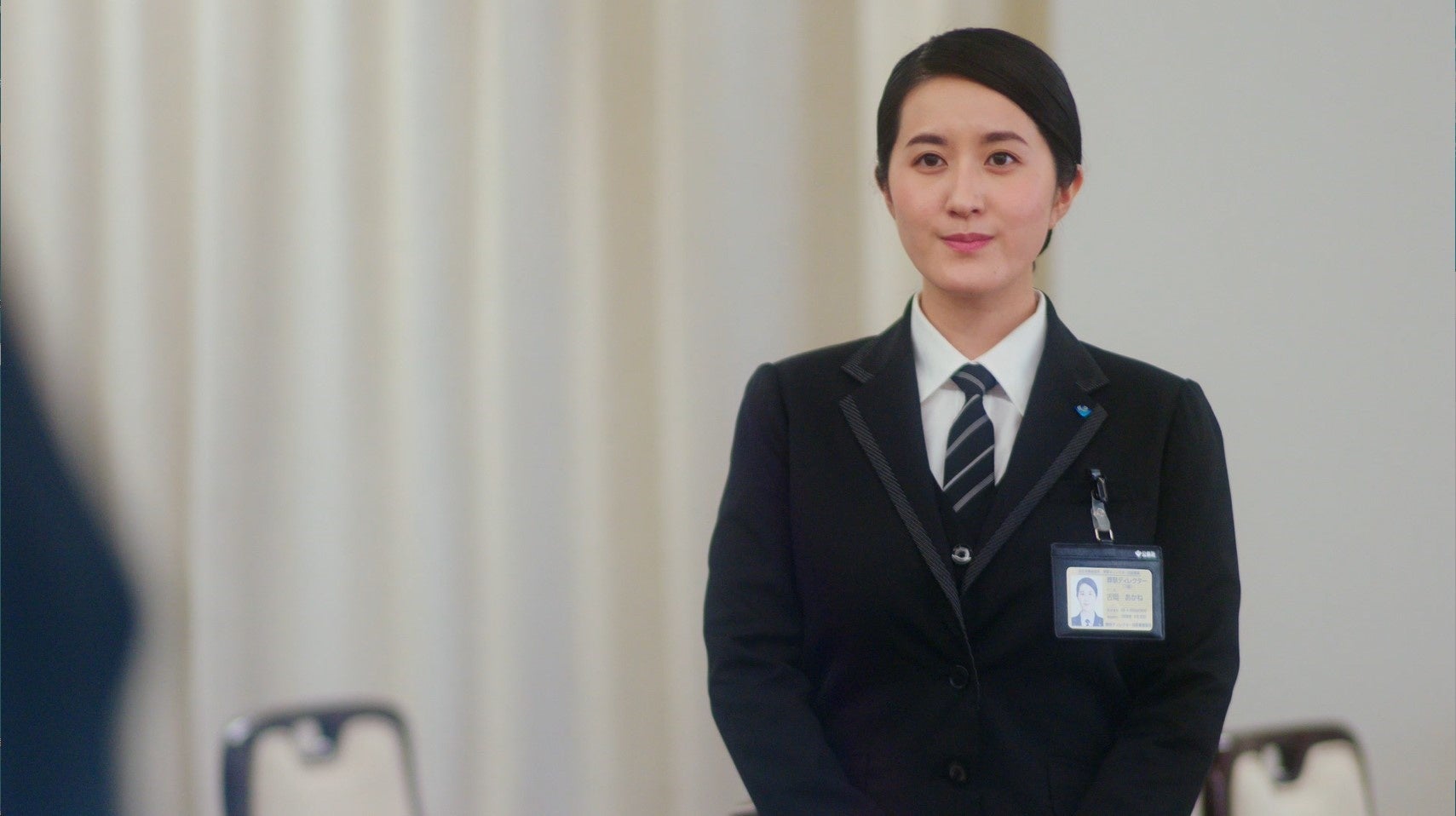 暖かい眼差しで会釈する葬祭ディレクター