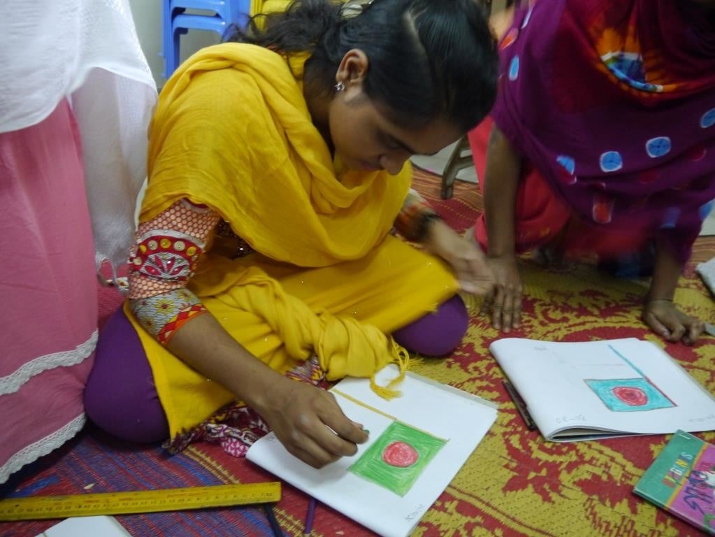 支援センターでバングラデシュの国旗の絵を描く少女