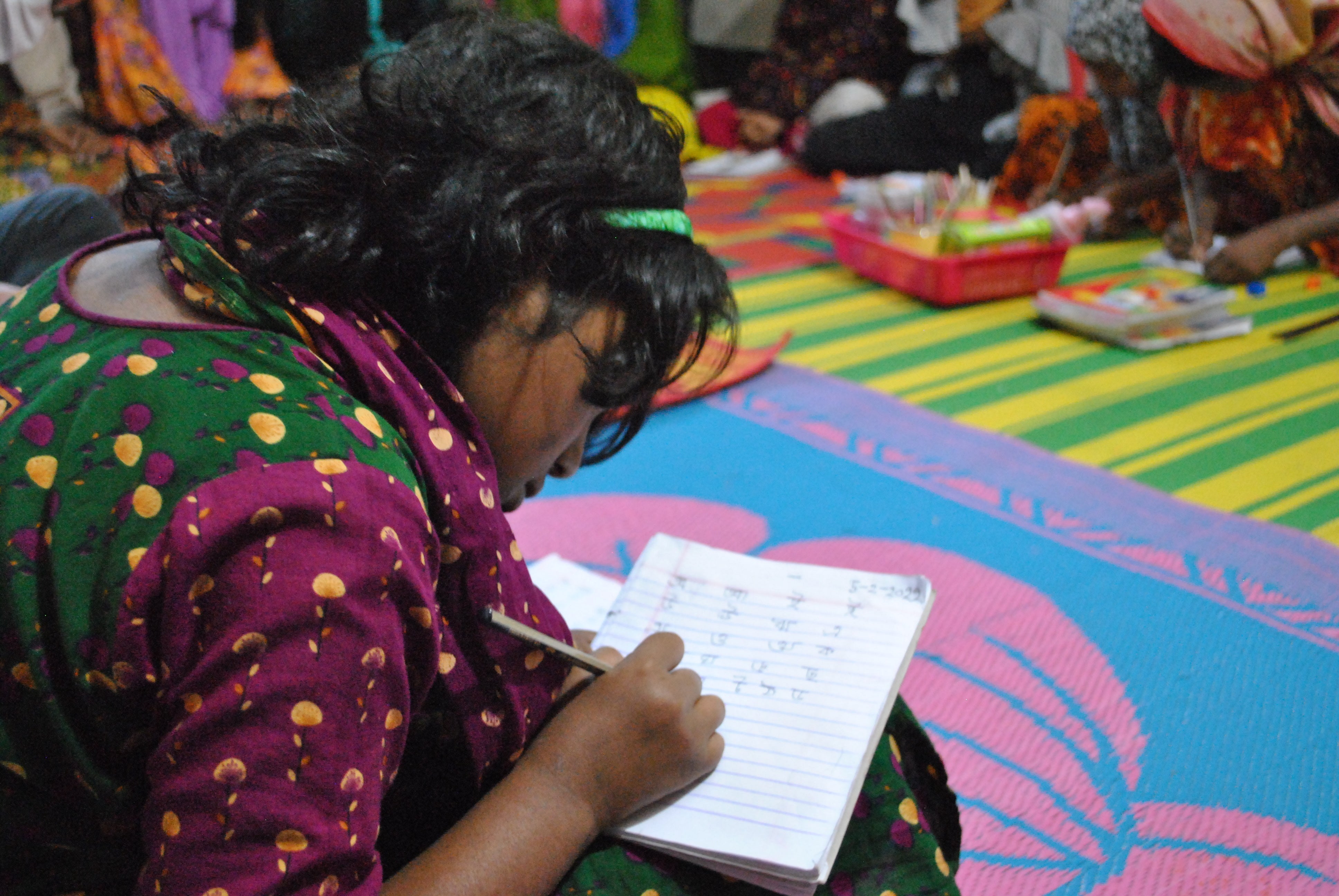 支援センターで読み書きを学ぶ家事使用人として働く少女の様子