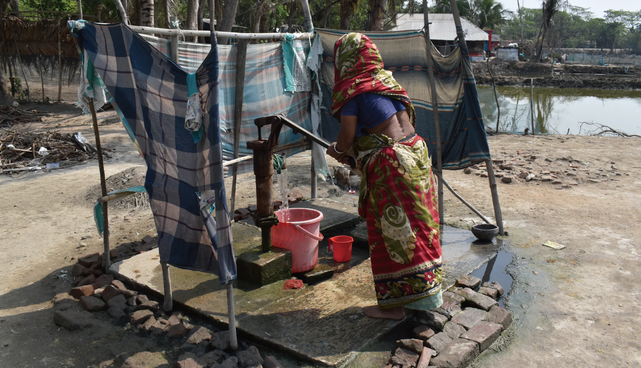 水汲みをする女性。海面に近い場所は災害時に井戸に海水が流れ込み、飲み水の確保が困難になる（バングラデシュ）