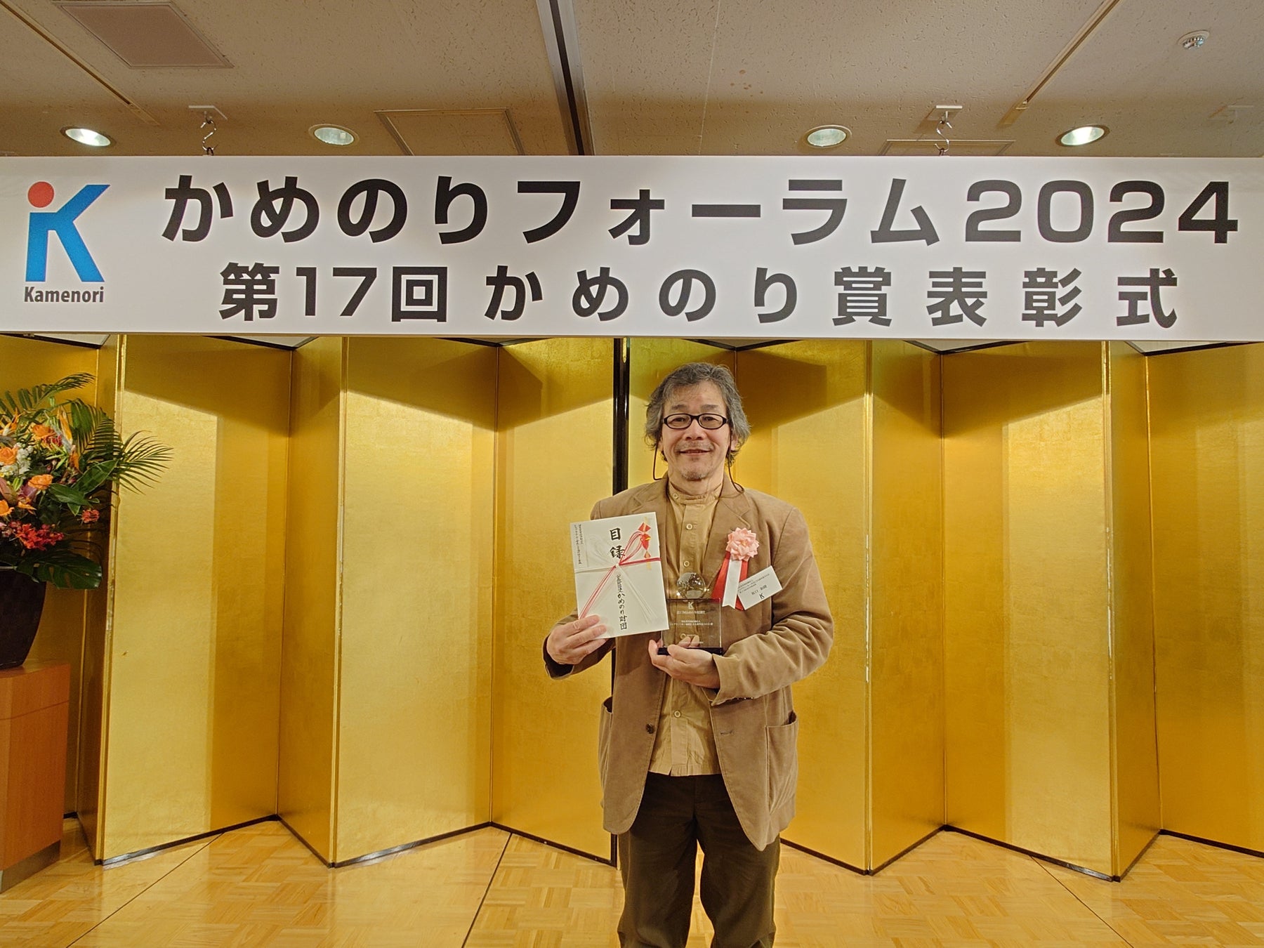 記念の盾とともに。代表理事 坂口