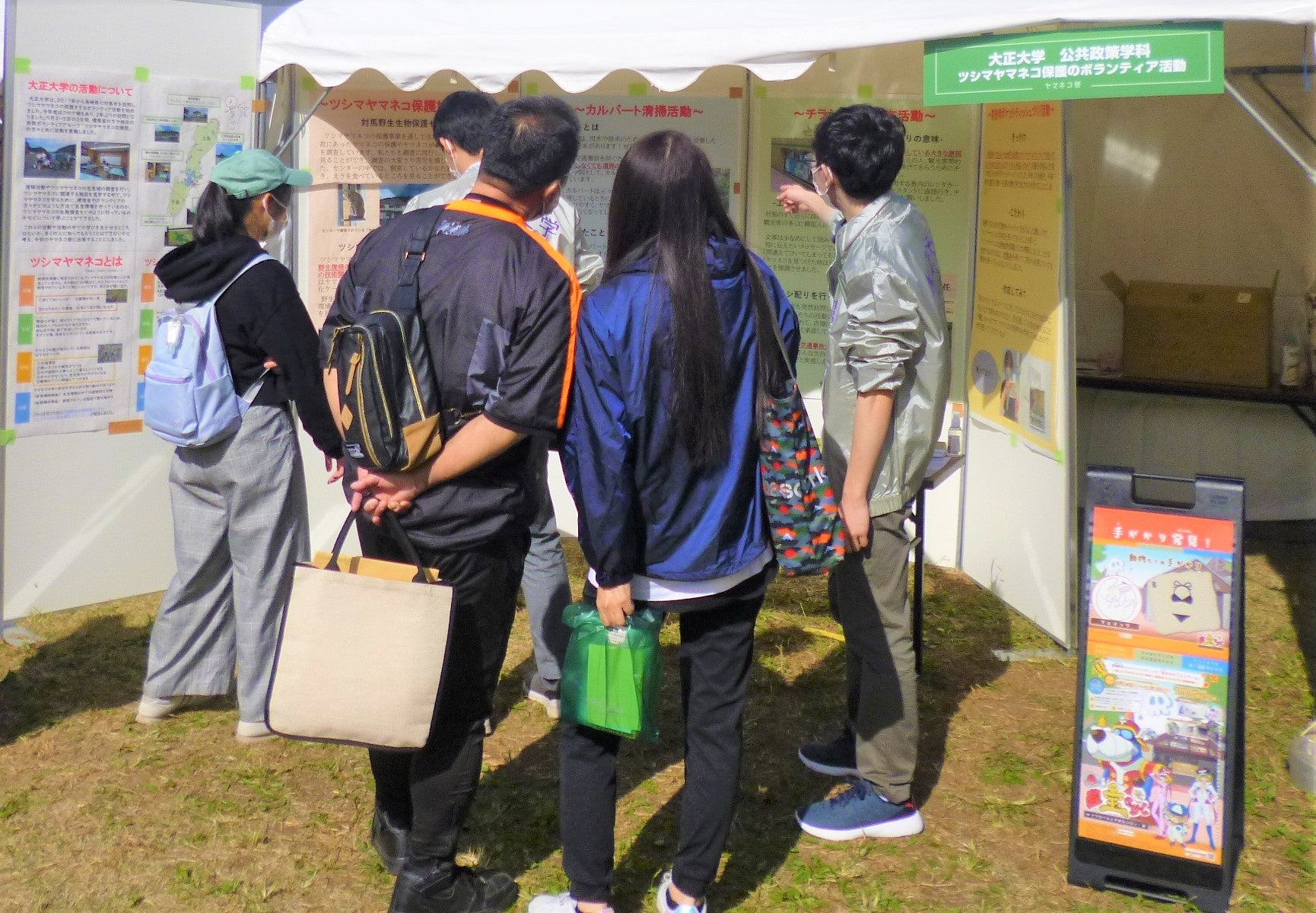 ブースへの来場者へ保護活動の内容を説明する学生　