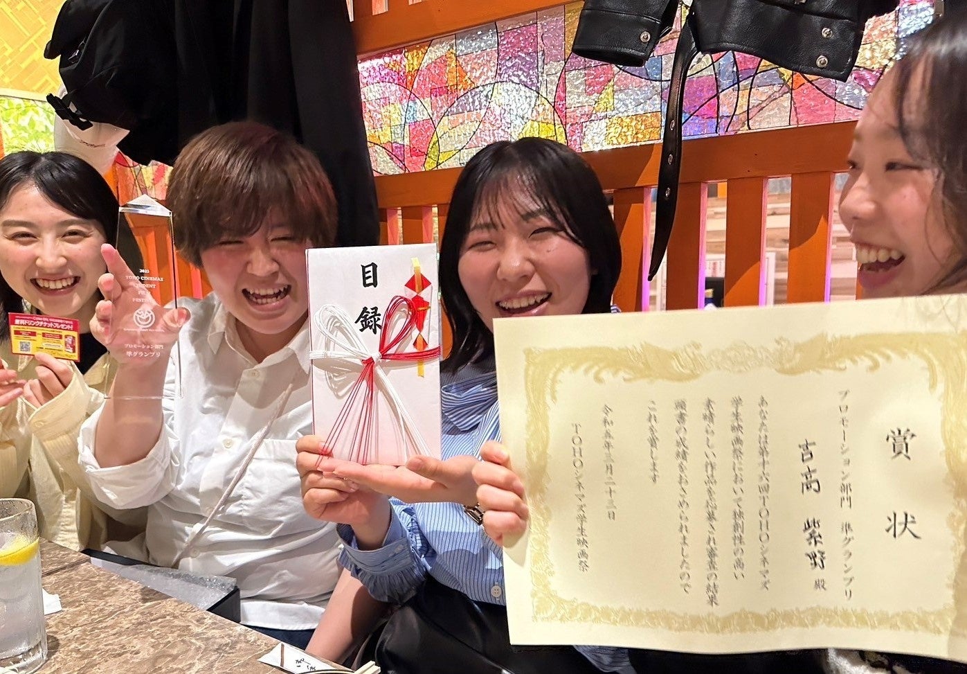 賞状を手に笑顔の学生