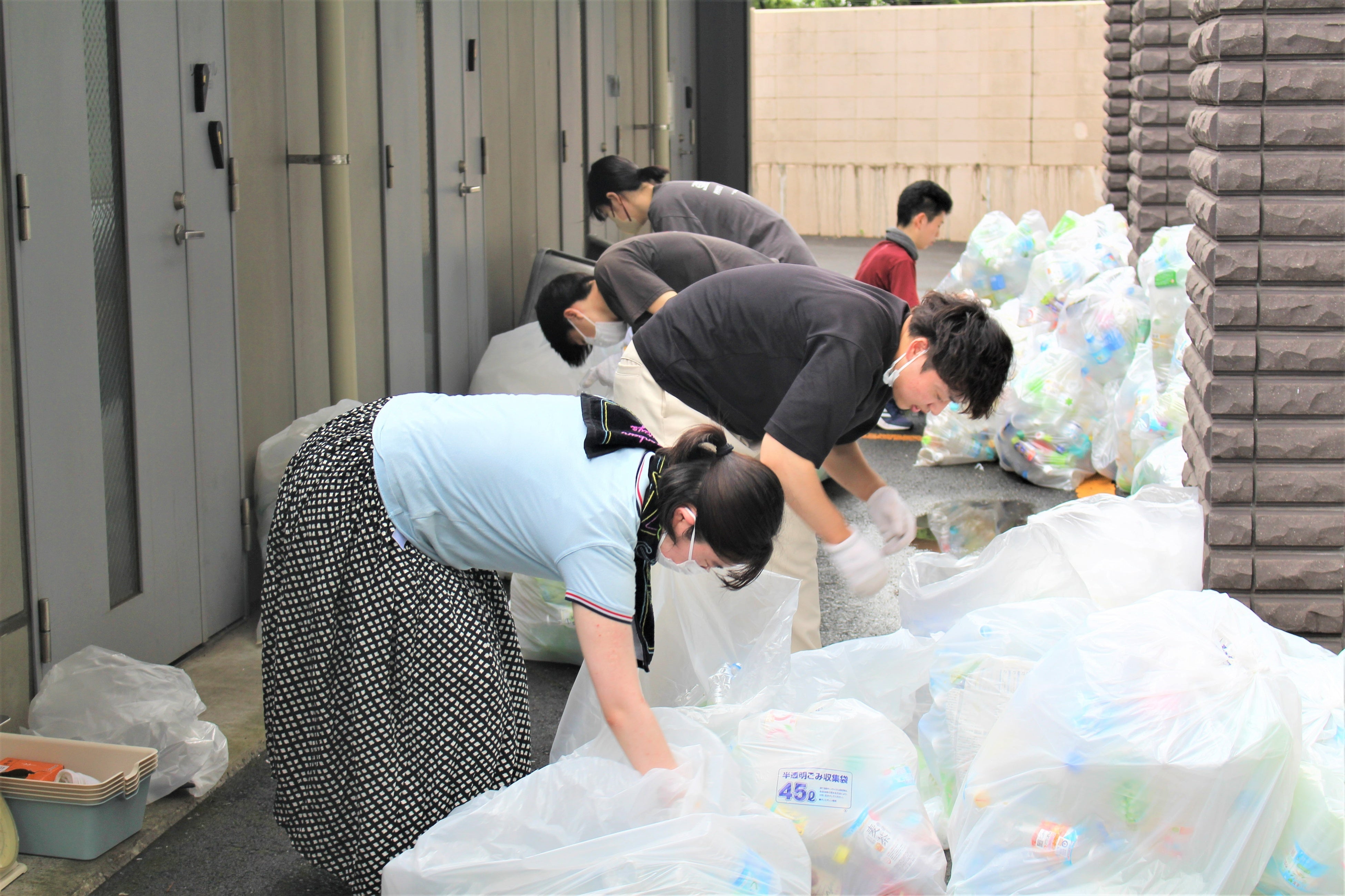 ペットボトルごみの量を調査する岡山ゼミと環境サークルsmileの学生の様子