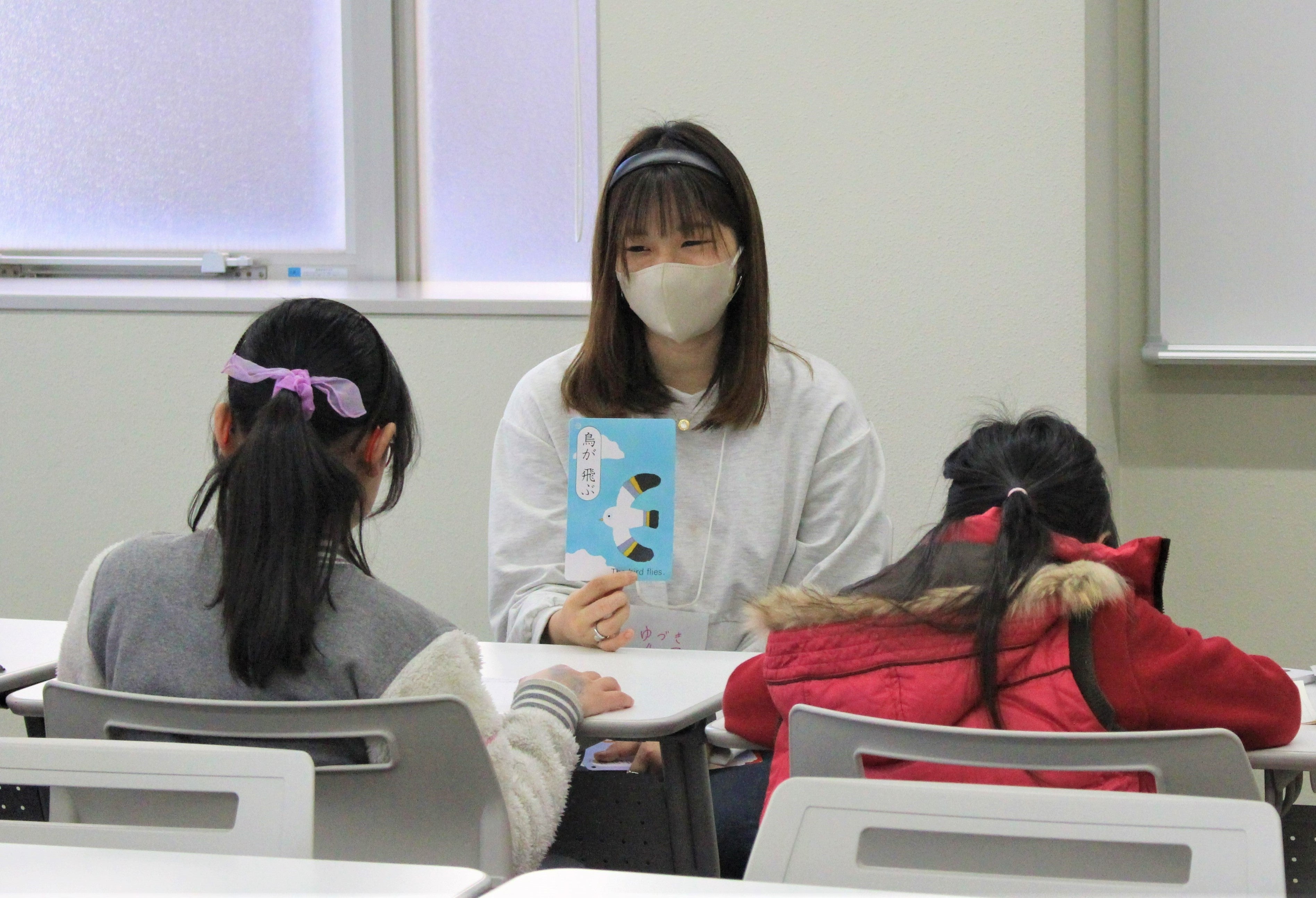 ホワイトボードに日本地図を書いたり絵カードを使用するなど、参加者の日本語習得状況に合わせて臨機応変に支援する本学学生。