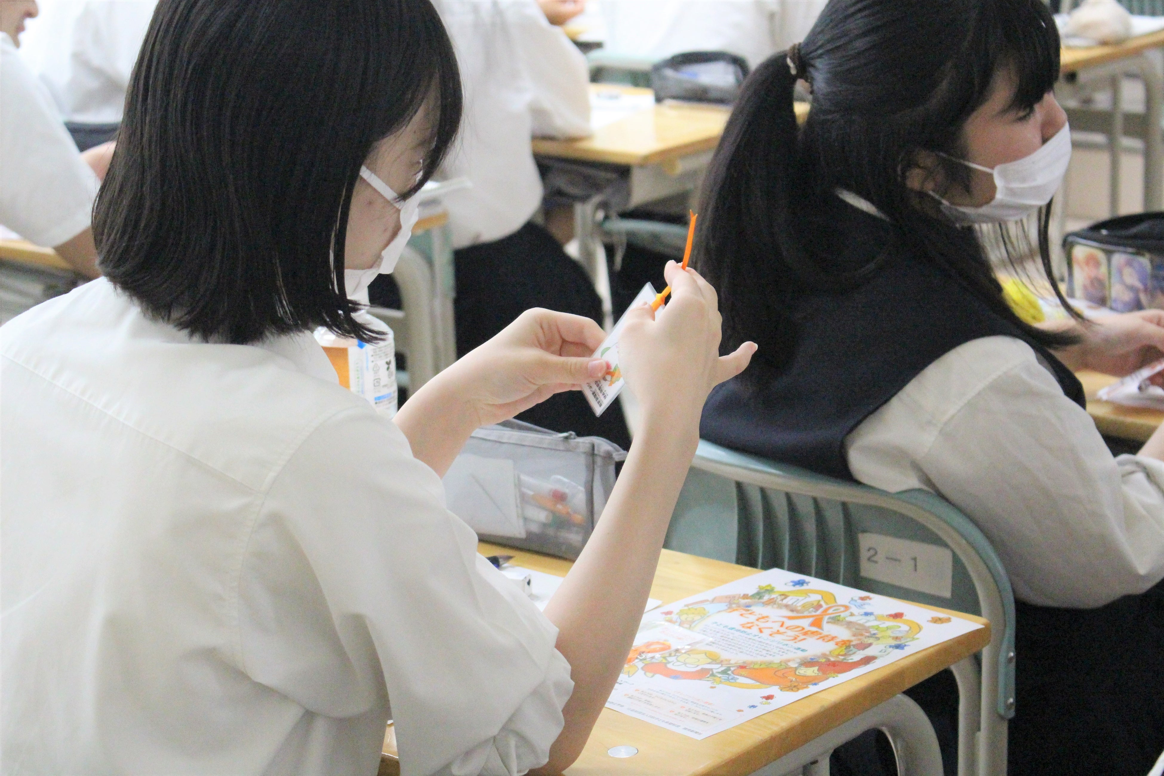 学生が制作した啓発グッズを手に取る生徒